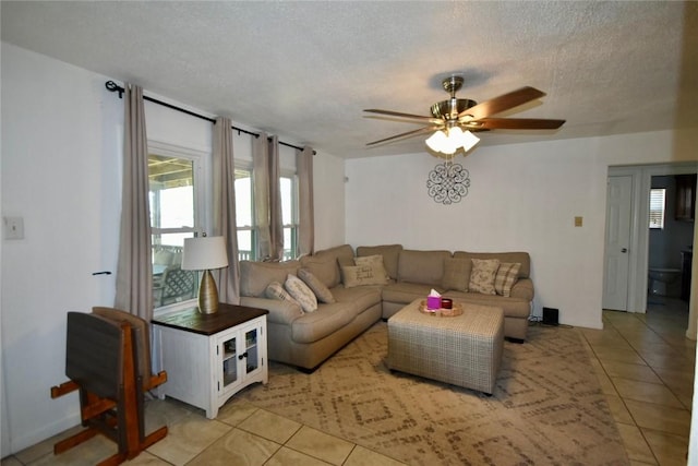 living room with light tile patterned floors, a textured ceiling, and a ceiling fan