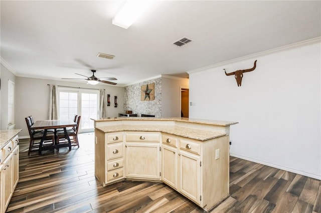 kitchen featuring crown molding, dark wood-type flooring, a kitchen island, and ceiling fan