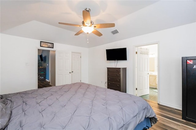 bedroom with hardwood / wood-style floors, ensuite bathroom, and ceiling fan