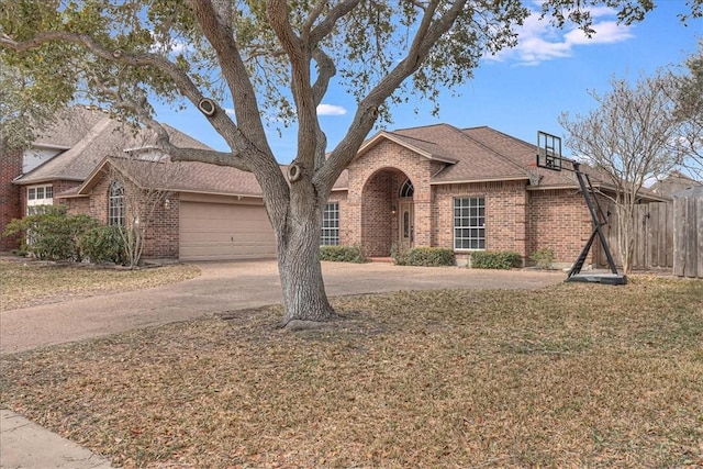 view of front of house with an attached garage, a front lawn, concrete driveway, and brick siding