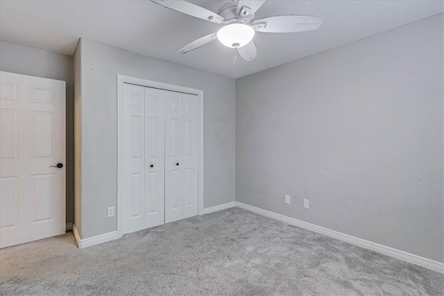 unfurnished bedroom featuring carpet, baseboards, ceiling fan, and a closet