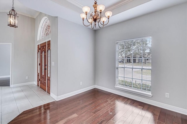 interior space featuring wood finished floors, baseboards, and an inviting chandelier