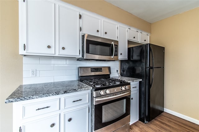 kitchen featuring tasteful backsplash, light stone countertops, white cabinets, and stainless steel appliances