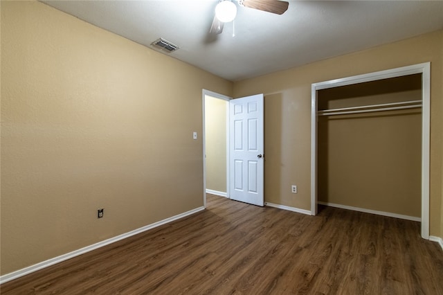 unfurnished bedroom with dark wood-type flooring, ceiling fan, and a closet