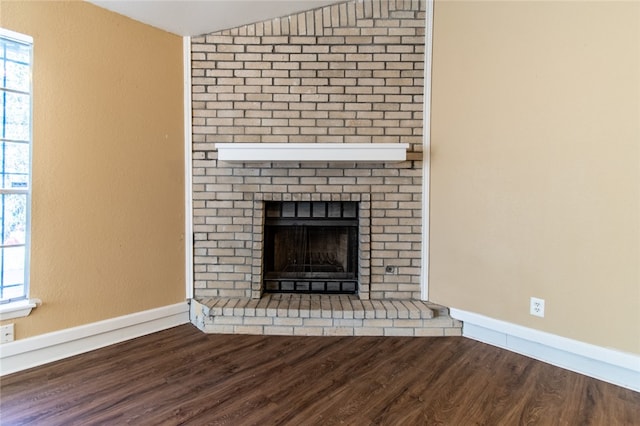 interior details featuring hardwood / wood-style floors and a brick fireplace