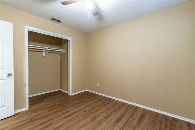 unfurnished bedroom with hardwood / wood-style flooring, ceiling fan, and a closet