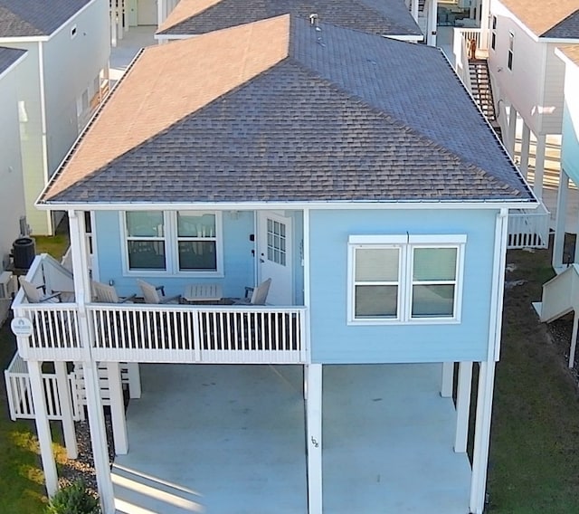 rear view of property with a carport and central AC unit