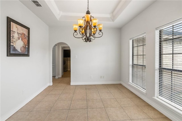unfurnished room featuring visible vents, an inviting chandelier, a tray ceiling, arched walkways, and light tile patterned floors