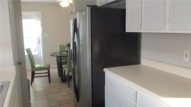 kitchen with ceiling fan, white cabinetry, light tile patterned floors, and stainless steel fridge