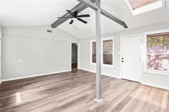 interior space with vaulted ceiling with skylight, light hardwood / wood-style floors, and a healthy amount of sunlight