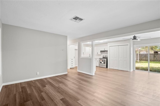 unfurnished living room featuring ceiling fan and light hardwood / wood-style flooring