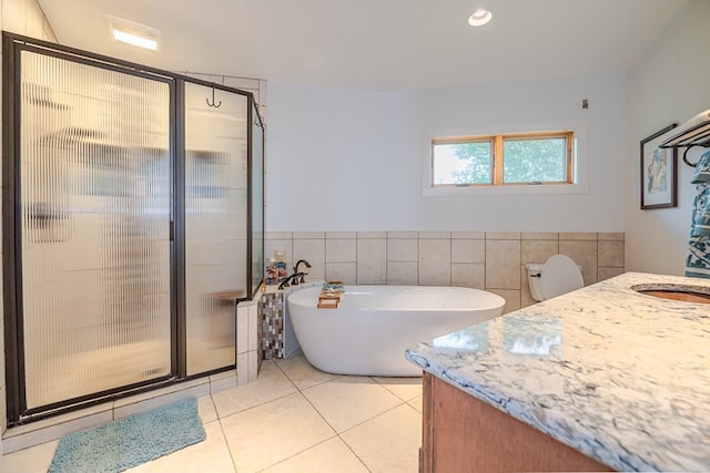 bathroom with tile walls, vanity, tile patterned flooring, and a shower with door