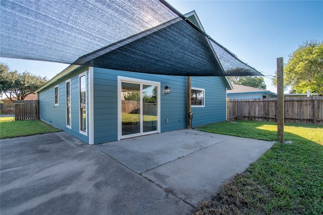 back of house with a lawn and a patio area