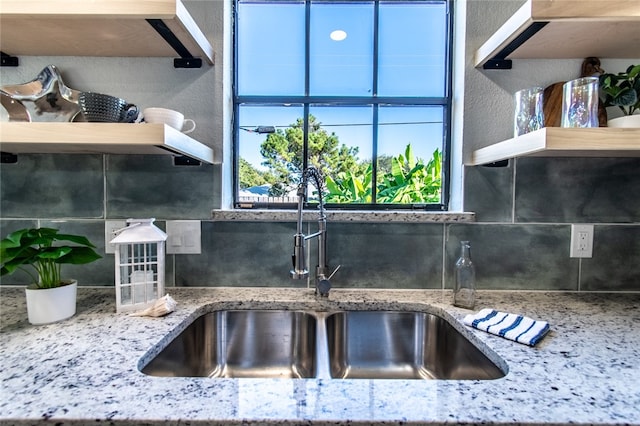 kitchen featuring light stone countertops and sink