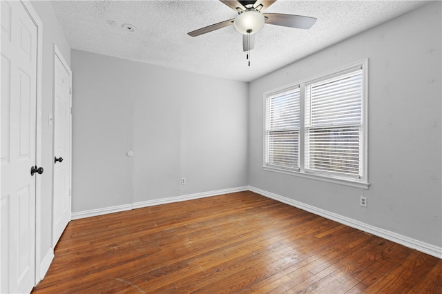 spare room with dark hardwood / wood-style flooring, a textured ceiling, and ceiling fan