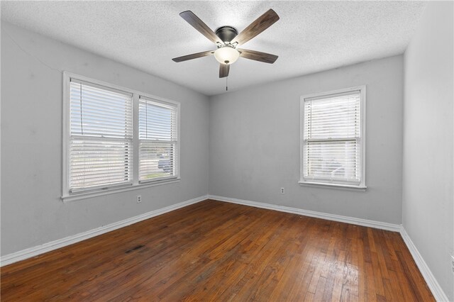 unfurnished room featuring ceiling fan, dark hardwood / wood-style floors, and a textured ceiling