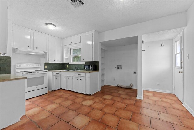 538 Southern St, Corpus Christi, TX 78404 - kitchen with white electric stove, stainless steel microwave, under cabinet range hood, white cabinets, and light countertops