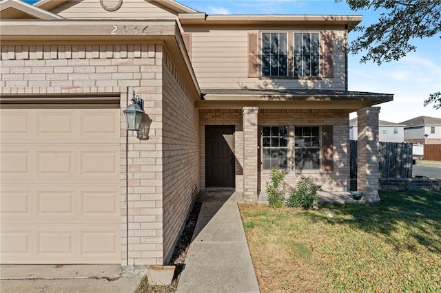 entrance to property featuring a garage and a yard