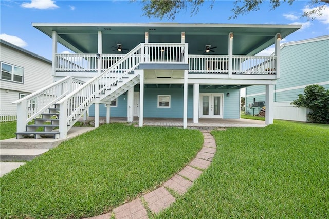 rear view of house featuring a lawn, french doors, ceiling fan, a patio area, and a deck