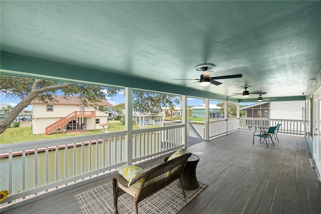 wooden terrace with a water view and a sunroom