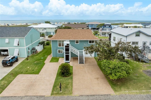 view of front of property featuring a front lawn and a water view