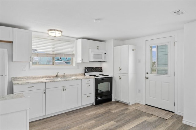 kitchen with light hardwood / wood-style floors, white cabinetry, sink, and black range with electric cooktop