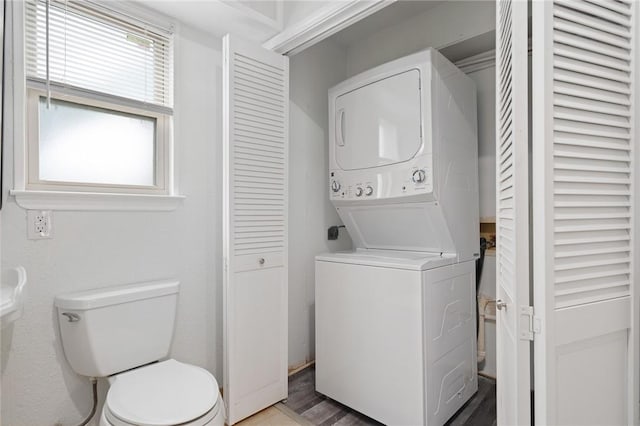 laundry area featuring hardwood / wood-style floors and stacked washer and dryer