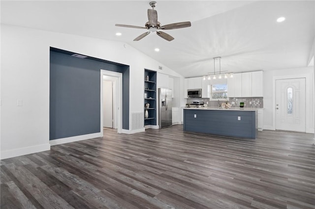 unfurnished living room with lofted ceiling, ceiling fan with notable chandelier, and dark wood-type flooring