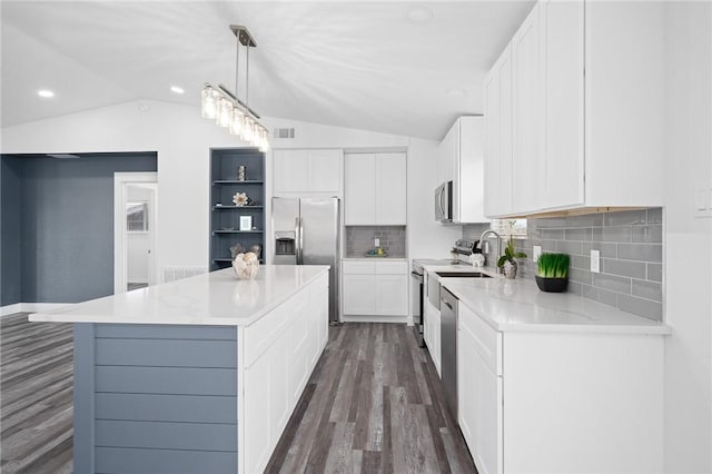 kitchen featuring a kitchen island, white cabinetry, hanging light fixtures, and vaulted ceiling