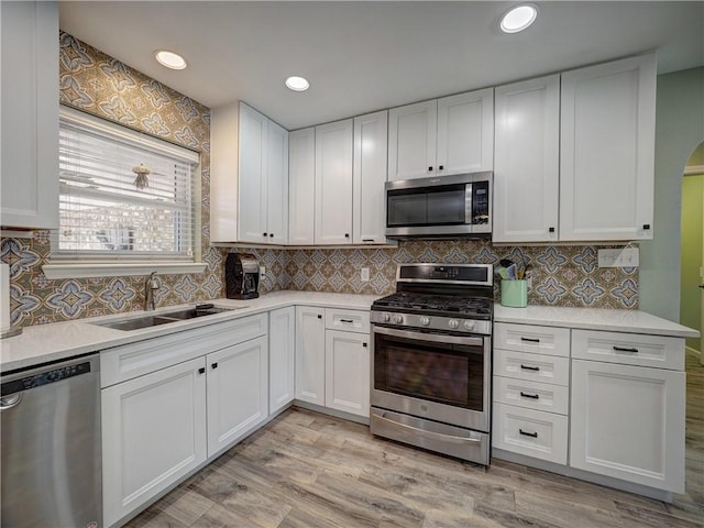 14350 Aquarius St, Corpus Christi, TX 78418 - kitchen with appliances with stainless steel finishes, a sink, light countertops, white cabinets, and backsplash