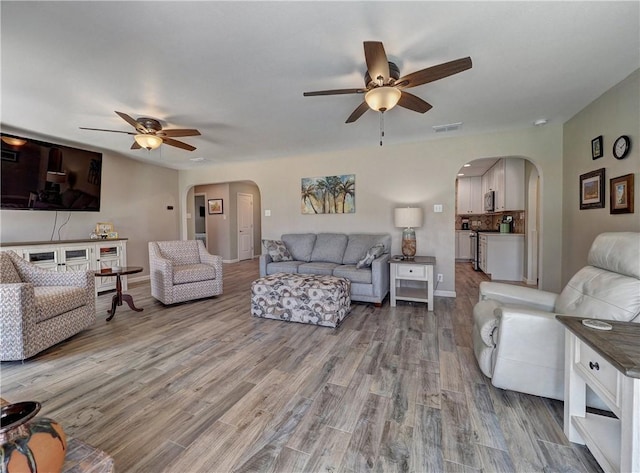 14350 Aquarius St, Corpus Christi, TX 78418 - living room featuring a ceiling fan, arched walkways, and wood finished floors