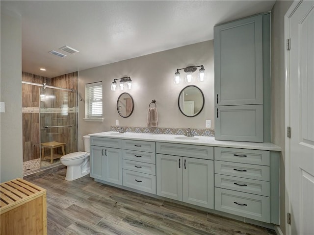 14350 Aquarius St, Corpus Christi, TX 78418 - full bathroom featuring double vanity, a stall shower, toilet, and wood finished floors