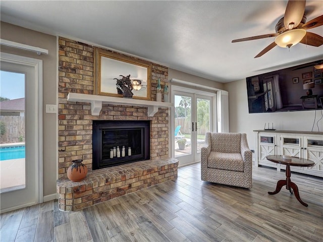 14350 Aquarius St, Corpus Christi, TX 78418 - living area with wood finished floors, a ceiling fan, french doors, and a brick fireplace