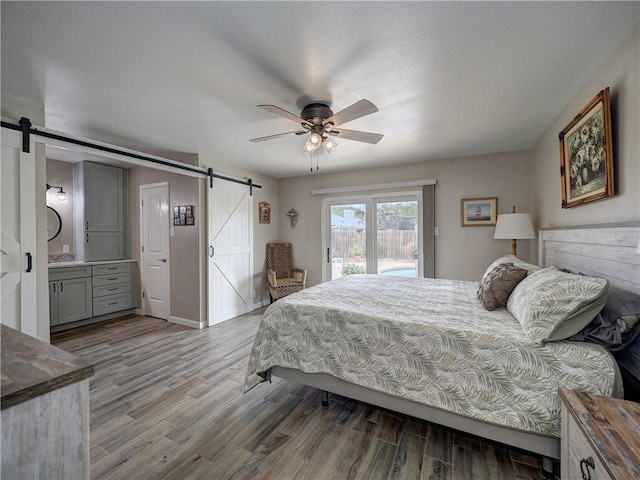 14350 Aquarius St, Corpus Christi, TX 78418 - bedroom with a barn door, access to outside, light wood-style floors, and connected bathroom