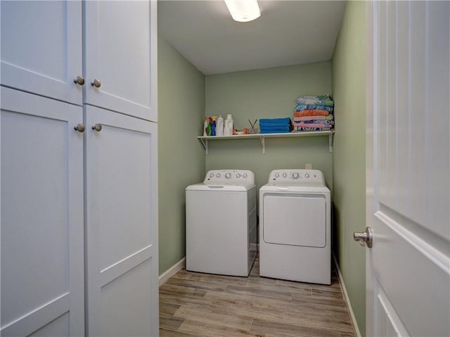 14350 Aquarius St, Corpus Christi, TX 78418 - laundry room featuring washing machine and clothes dryer, cabinet space, baseboards, and light wood-type flooring