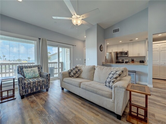 living room featuring high vaulted ceiling, wood-type flooring, and ceiling fan