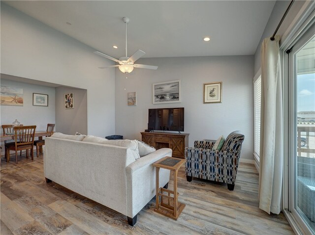 living room with light wood-type flooring, lofted ceiling, and ceiling fan