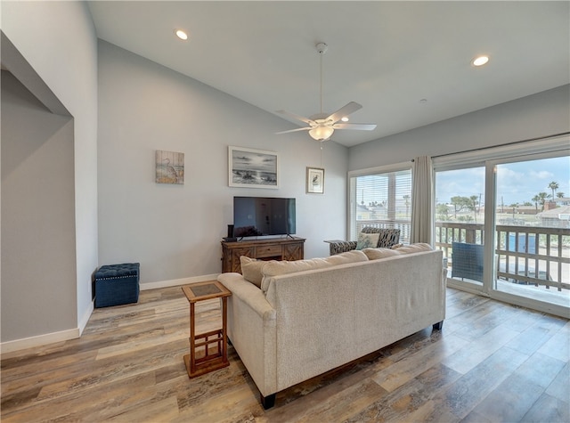 living room featuring lofted ceiling, hardwood / wood-style flooring, and ceiling fan