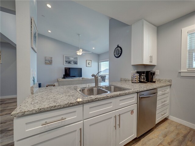 kitchen with lofted ceiling, dishwasher, kitchen peninsula, sink, and white cabinetry