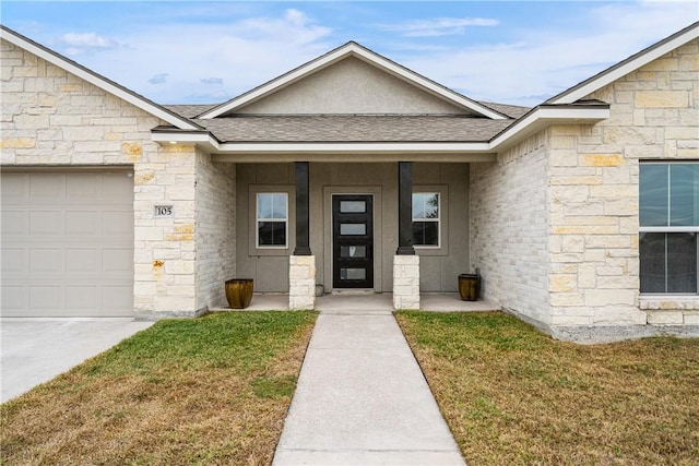 view of exterior entry featuring a garage and a yard