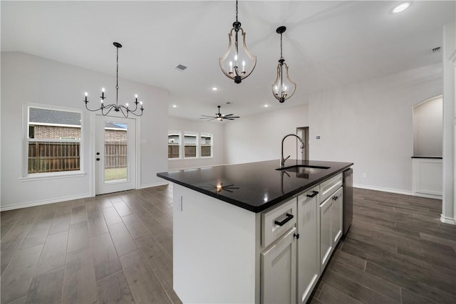 kitchen featuring ceiling fan, sink, hanging light fixtures, and an island with sink