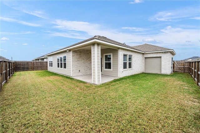 rear view of property with a yard and a patio