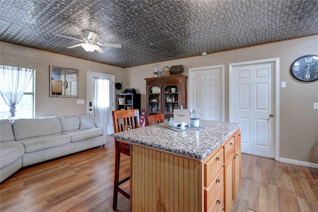 1820 16th St, Rockport, TX 78382 - kitchen featuring a breakfast bar, open floor plan, an ornate ceiling, ceiling fan, and light wood finished floors