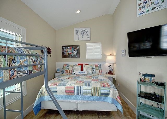 bedroom with vaulted ceiling and wood-type flooring