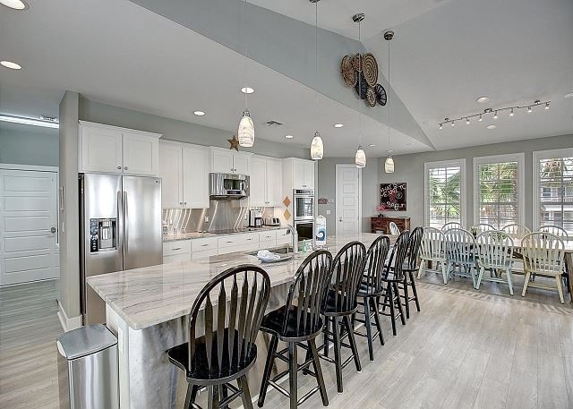 kitchen with lofted ceiling, white cabinets, a large island, and appliances with stainless steel finishes