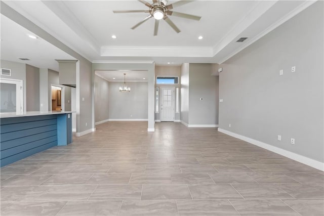 unfurnished living room with ceiling fan with notable chandelier, a tray ceiling, and ornamental molding