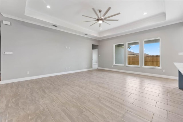 spare room featuring a raised ceiling and ceiling fan