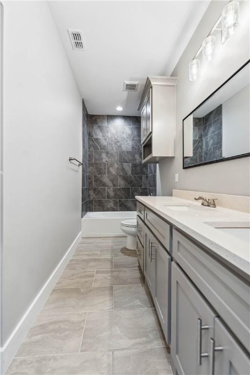 full bathroom with vanity, tiled shower / bath combo, and toilet