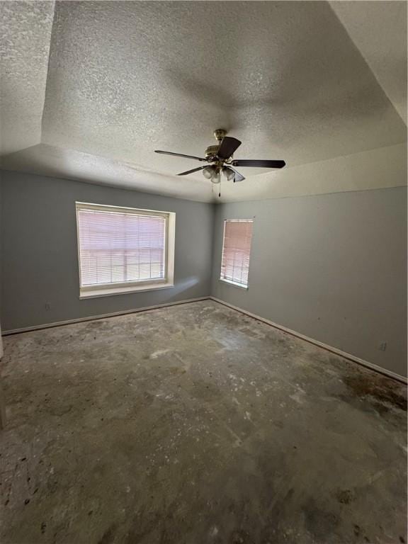 unfurnished room featuring a textured ceiling, concrete floors, and ceiling fan