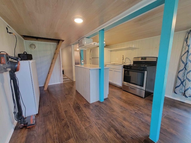 kitchen featuring white cabinetry, stainless steel gas range, dark hardwood / wood-style flooring, and washer / dryer